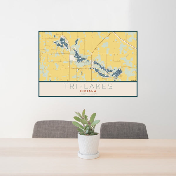 24x36 Tri-Lakes Indiana Map Print Lanscape Orientation in Woodblock Style Behind 2 Chairs Table and Potted Plant